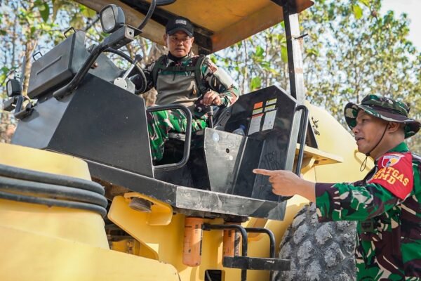 Pastikan kualitas pemadatan jalan, Dansatgas TMMD 129 Kodim 0812/Lamongan sambil menaiki Buldozer berinteraksi langsung dengan operator
