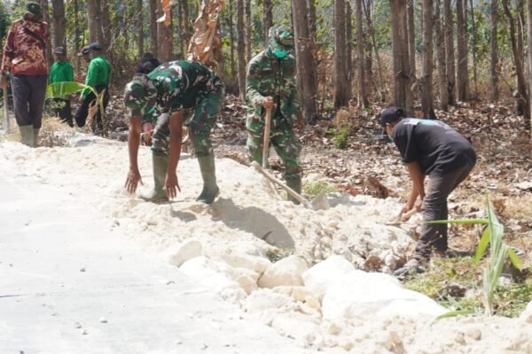 Perkokoh Bahu Jalan dan Keamanan Akses Desa, Satgas TMMD 129 dan Warga Uruk Sisi Jalan Rabat Beton Gunakan Padel