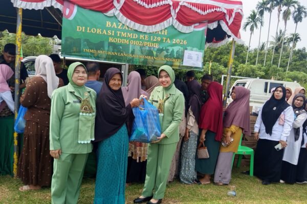 Ketua Persit KCK Cabang XIX Kodim 0102/Pidie dan Wakil Ketua Bhayangkari Polres Pidie Layani Warga di Bazar Murah TMMD ke-129