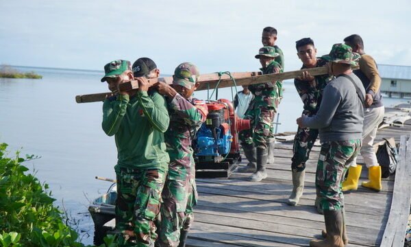Satgas TMMD Bersama Masyarakat Gotong Royong Memikul Mesin Air untuk Program Manunggal Air