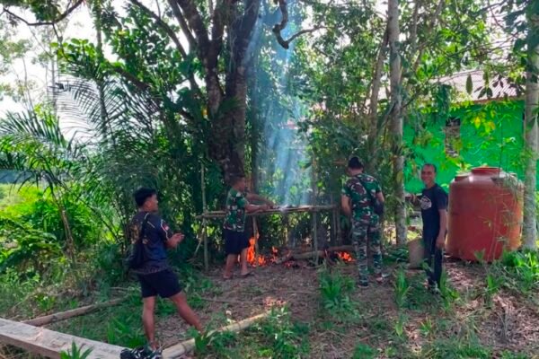 Di Sela-sela Kegiatan, Anggota Satgas TMMD Regtas Ke-129 Kodim 1206/Putussibau Bantu Warga Buat Salai Ikan