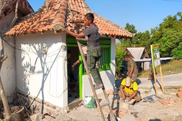 Tunjukkan Kepiawaian di Ketinggian, Sertu Edi Anggota Satgas TMMD 129 Lincah Panjat Atap Rampungkan Pemasangan dan Finishing Pos Kamling