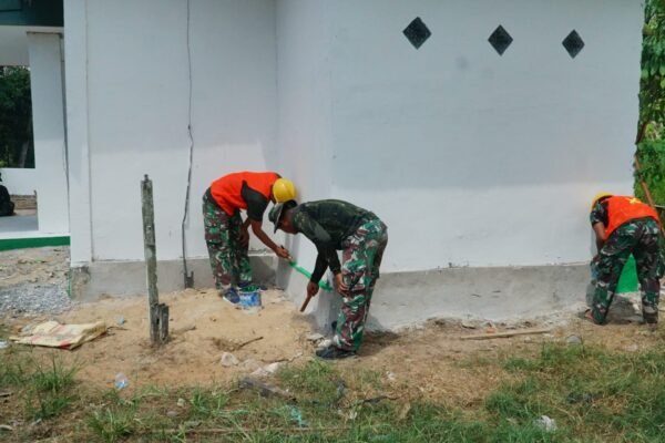 Tahap Finishing Musholla Darul Iman Terus Dimaksimalkan, Satgas TMMD Ke-129 Kerjakan Pengecatan Lis Pondasi